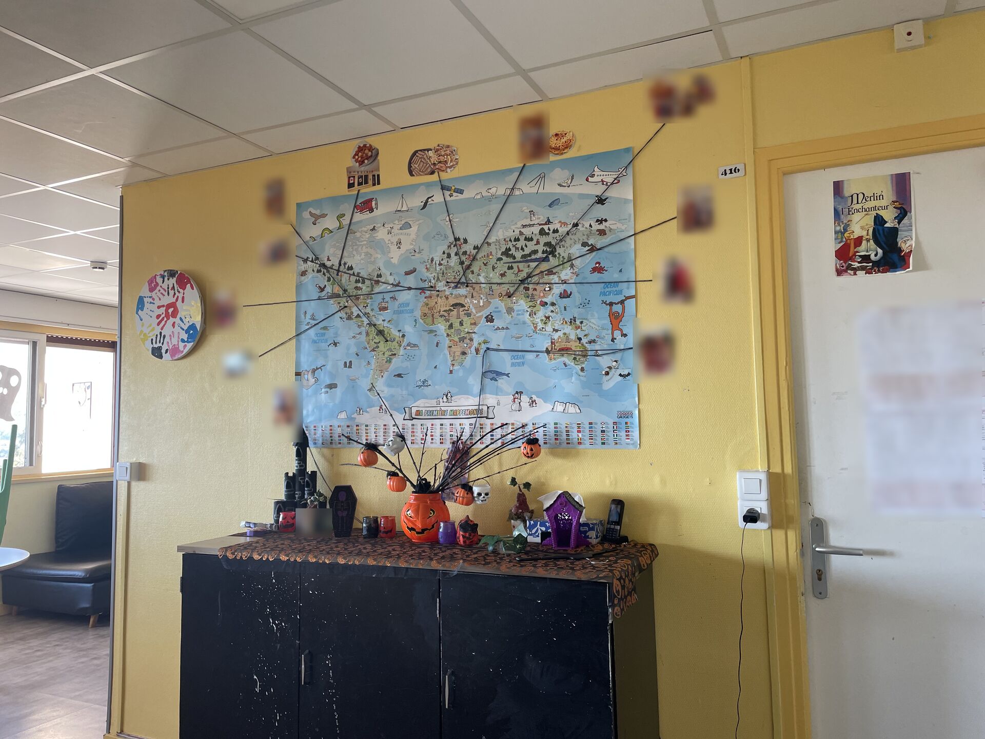 Carte du monde au mur avec fils reliant des photos de soirées à thème